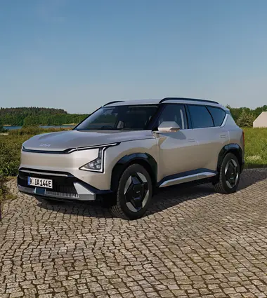 Kia EV5 auf Pflasterstein parkend in schöner Landschaft