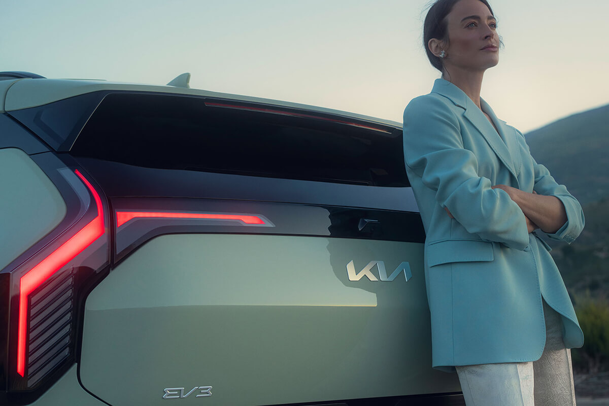 Eine Person lehnt am Heck des Kia EV3.