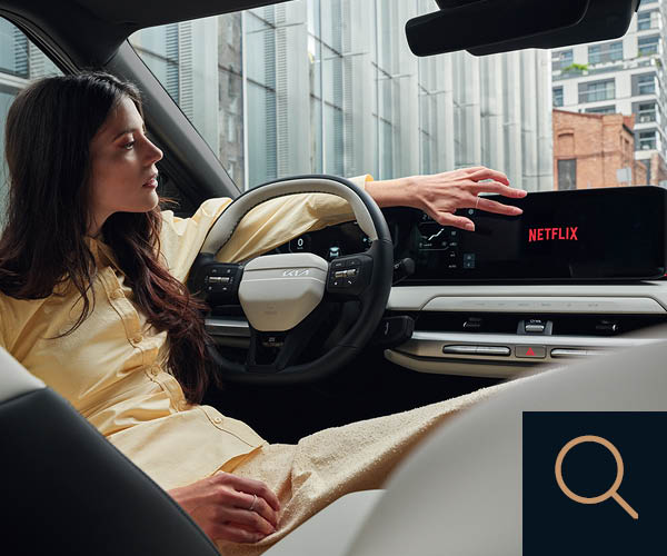 Frau sitzt auf Beifahrersitz und schaut Netflix