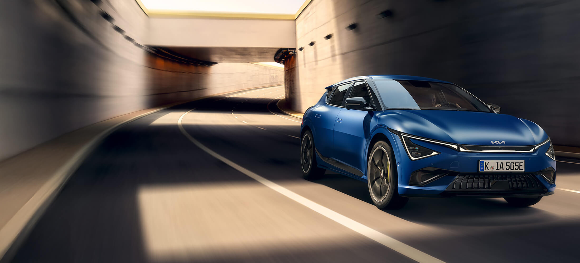 Kia EV6 GT, seitlich von vorne auf der Straße fahrend.