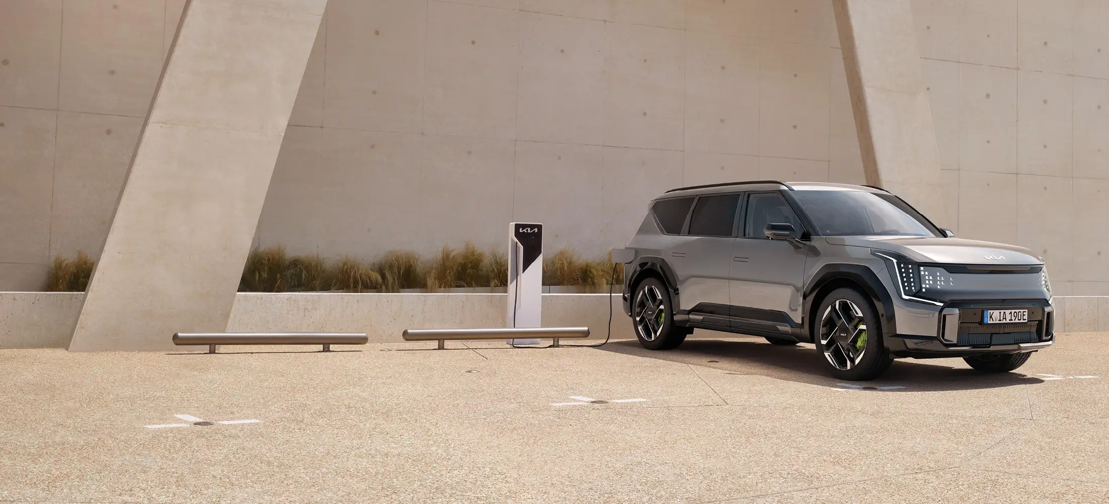 Kia EV9 GT steht vor einem Gebäude und lädt