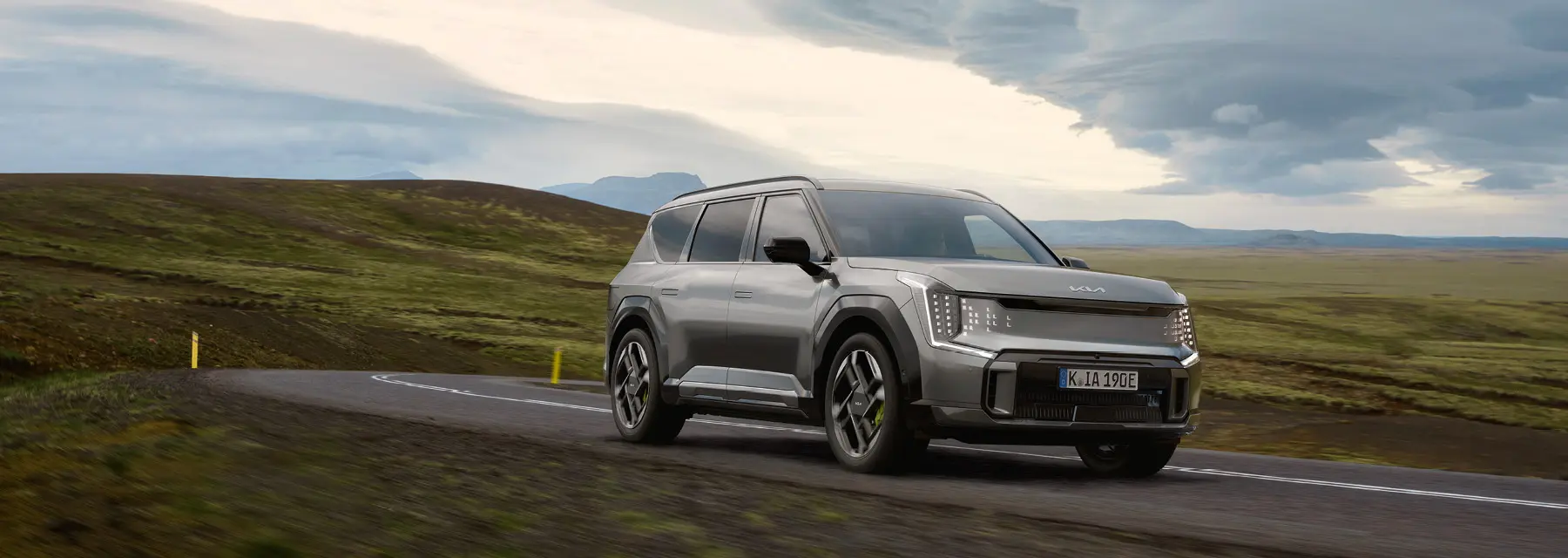 Kia EV5 seitlich von vorne vor der Garage eines Hauses