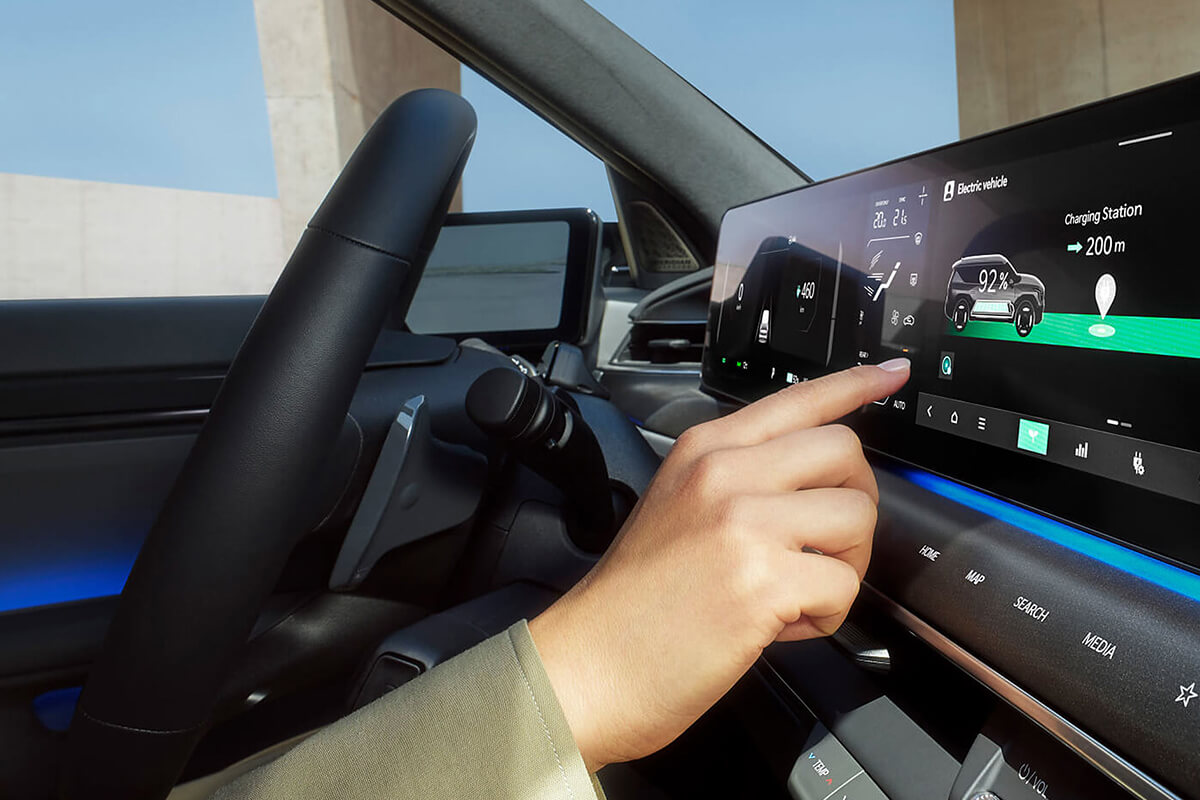 Man sieht eine Person im Fahrerraum, die den Touchscreen benutzt.