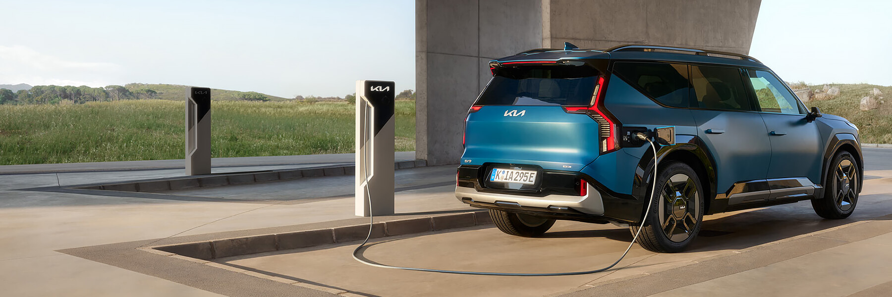 Kia EV9 GT-Line seitlich von hinten an einer Ladesäule.