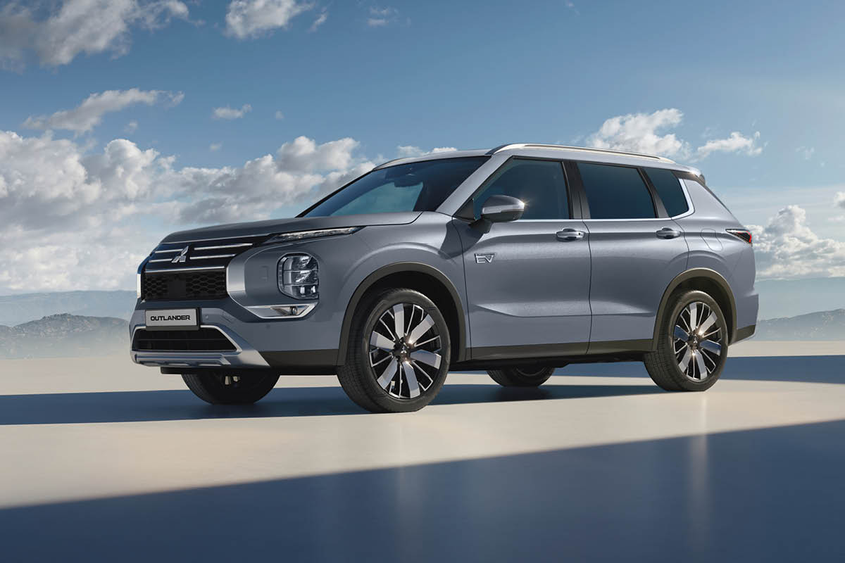 Outlander steht auf einer Plattform im Hintergrund blauer Himmel und Berglandschaft